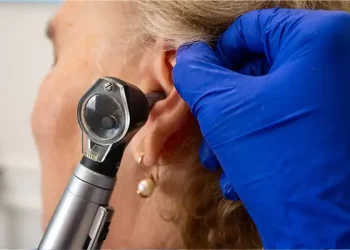 examining ear with otoscope